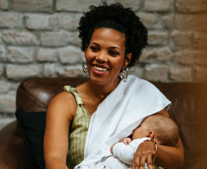 Black-mom-breastfeeding-baby-on-couch-2048×1365 1 (1)